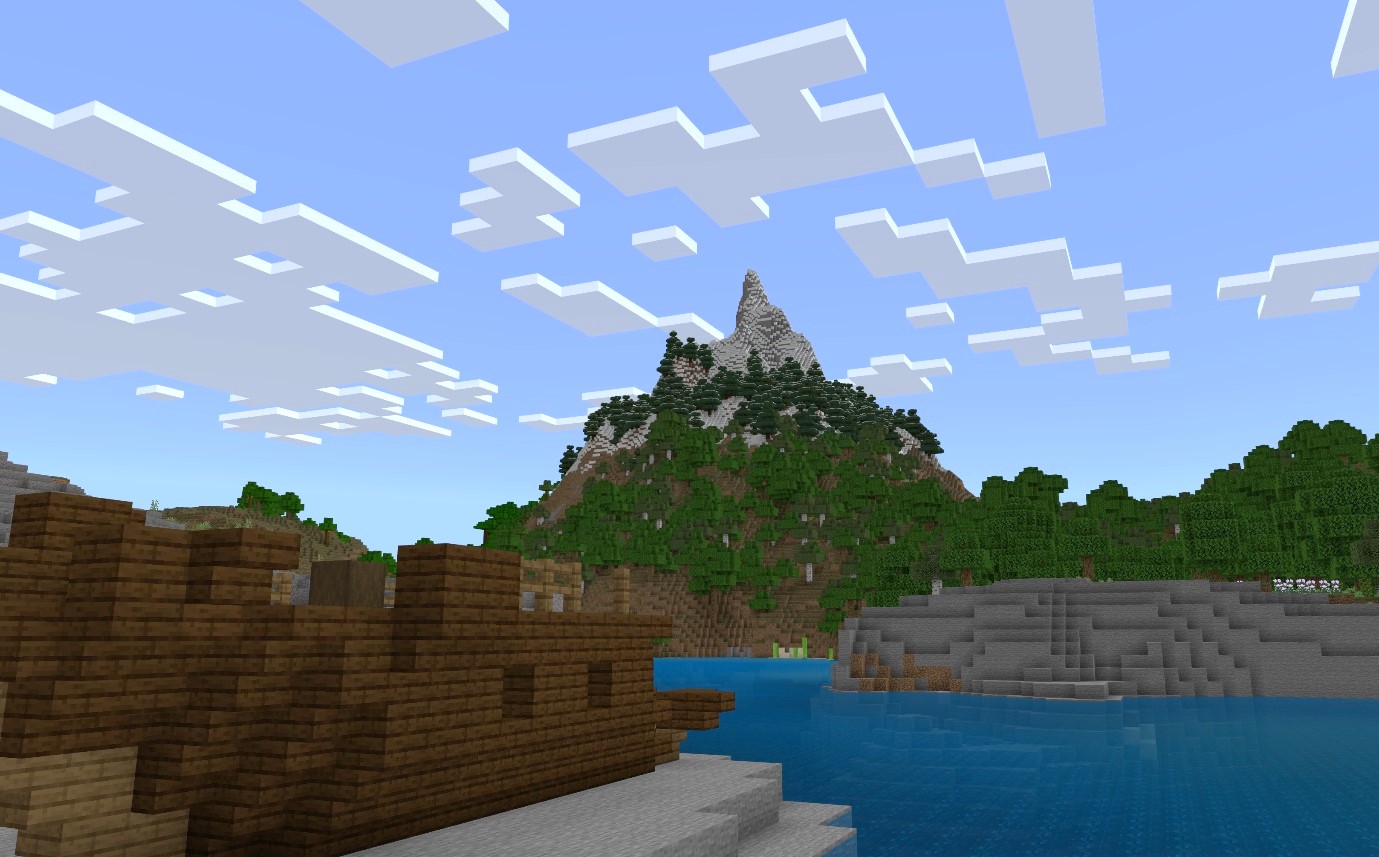 A Minecraft screenshot of a shipwreck near an impressive mountain